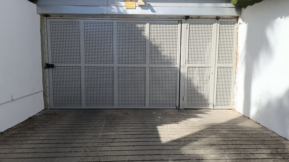 COMUNIDAD - Puerta batiente automática + fijo lateral en chapa troquelada cuadrada. Instalada en Manilva.